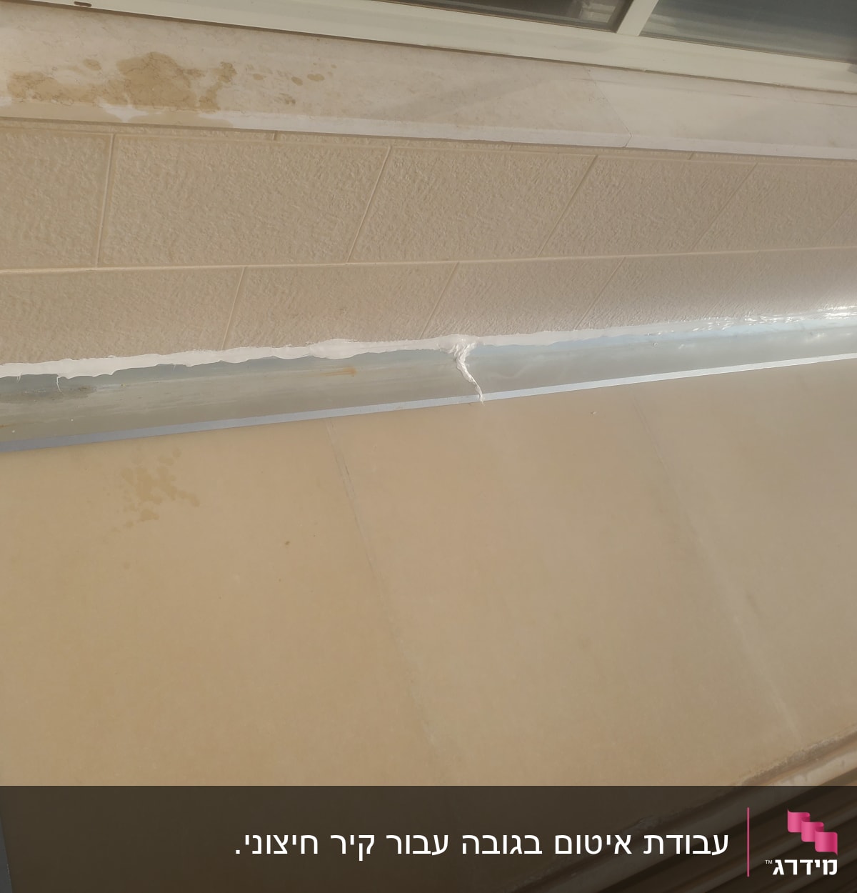 איטום עם חומר לבן על קיר וחלון